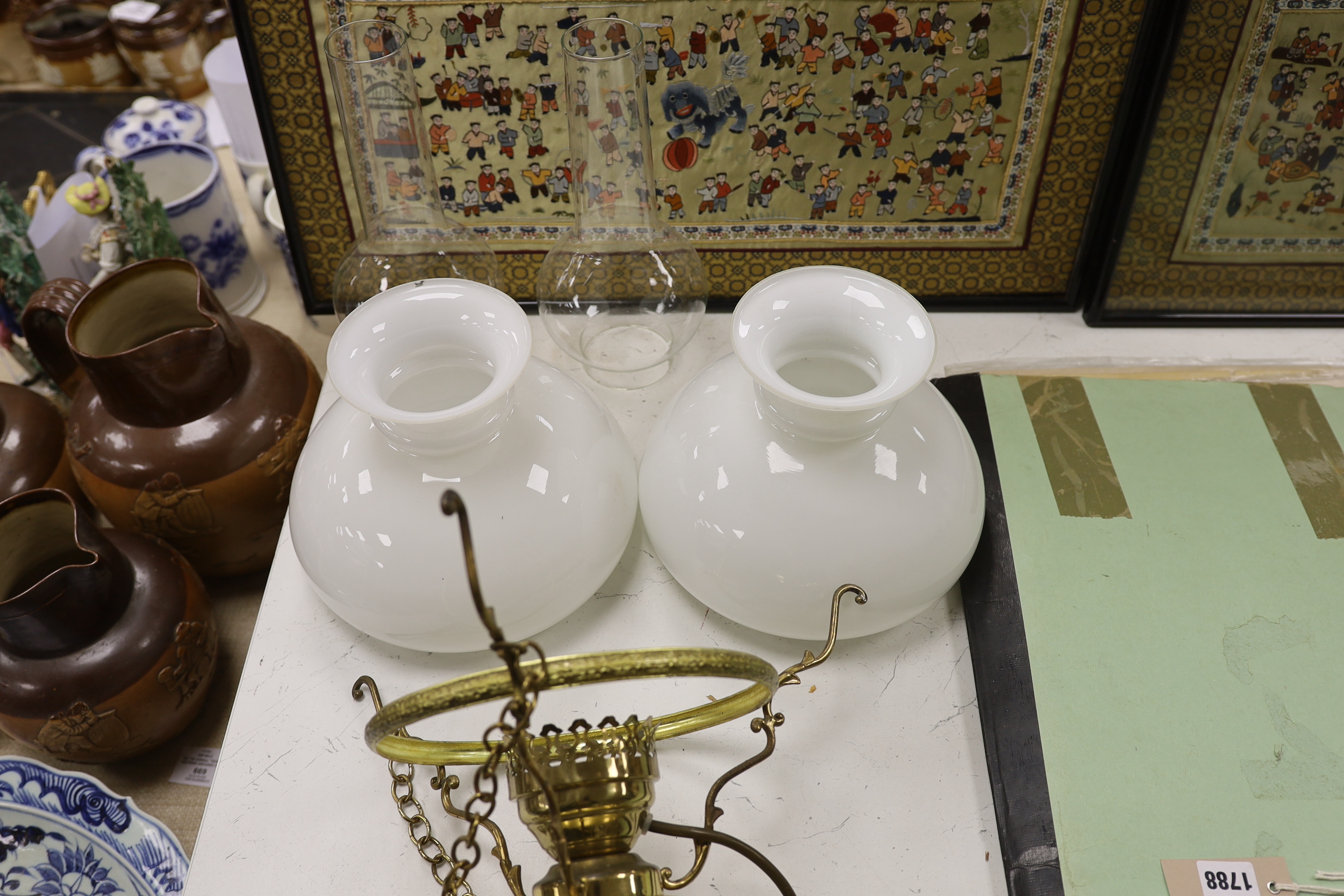 A pair of brass hanging lights with opaque glass shades